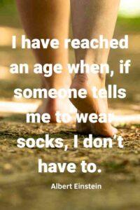 An image of a person's bare feet walking away on the  ground, with the text overlay:"I have reached an age when, if someone tells me to wear socks, I don't have to." ∼ Albert Einstein"